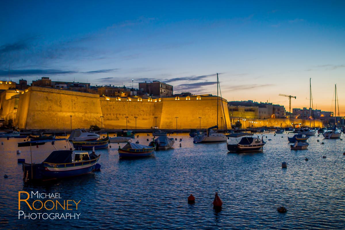 birgu malta walls fortification citadel lit dusk boats harbor bay